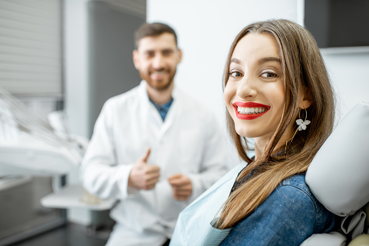 Portrait of a young woman with dentist in the dental office